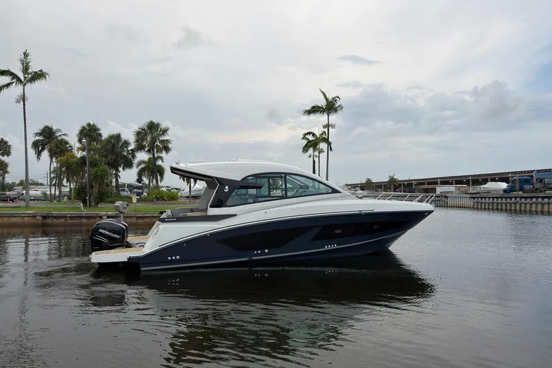 Slide: The Image of 2023 Beneteau Gran Turismo 32 yacht on calm water with palm trees in background. - 44