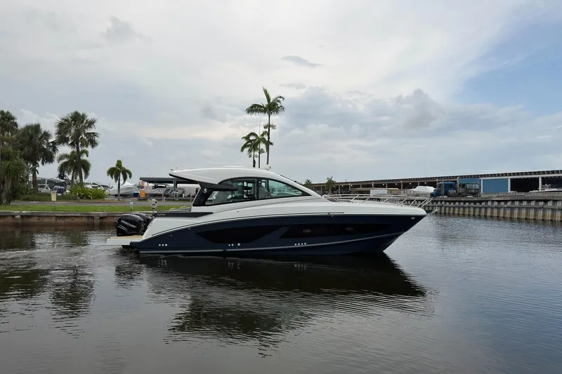 Slide: The Image of 2023 Beneteau Gran Turismo 32 yacht on calm water, surrounded by palm trees. - 45