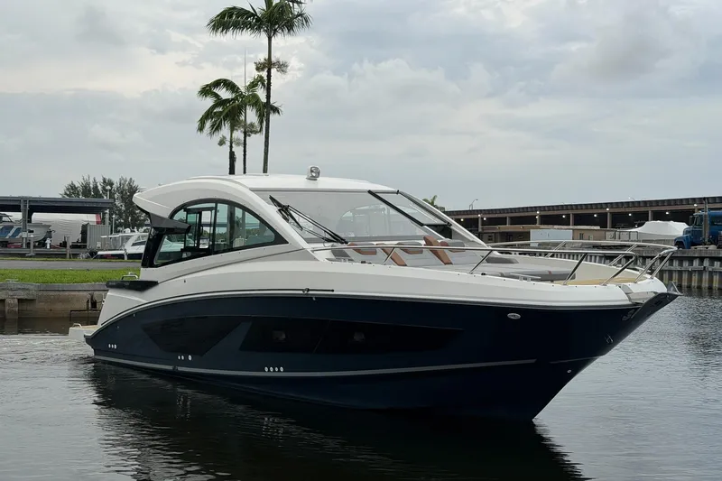 Slide: The Image of 2023 Beneteau Gran Turismo 32 yacht docked near palm trees, showcasing sleek design. - 49