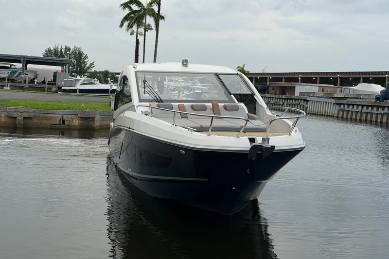 Slide: The Image of 2023 Beneteau Gran Turismo 32 yacht docked in a marina, surrounded by water and palm trees. - 50