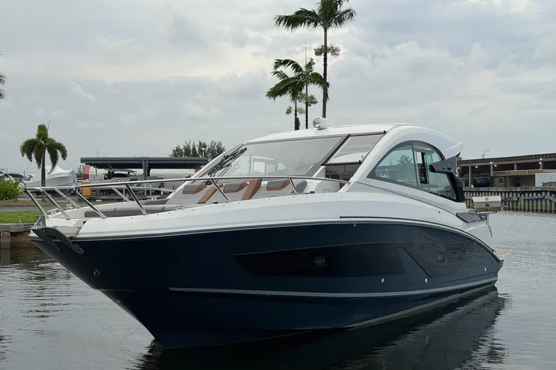 Slide: The Image of 2023 Beneteau Gran Turismo 32 yacht docked near palm trees, overcast sky. - 53