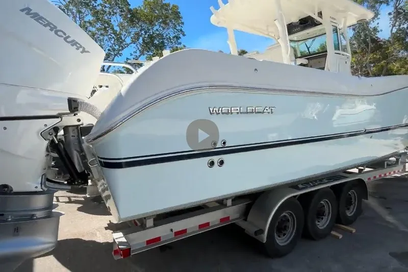 The Image of 2025 World Cat 325 CC boat on trailer, featuring Mercury engines, parked outdoors. - 0