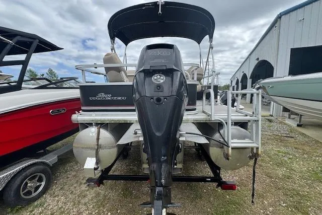 Slide: The Image of 2016 Sun Tracker Bass Buggy 18 DLX pontoon boat with outboard motor, docked outdoors. - 6