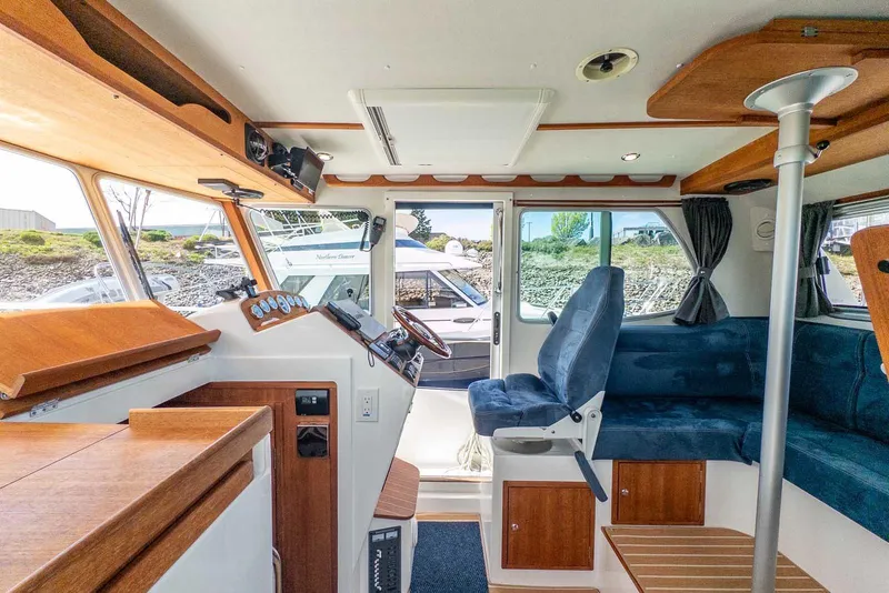 Slide: The Image of Interior of 2019 Nord Star 28 Patrol boat with blue seating and wooden accents. - 25