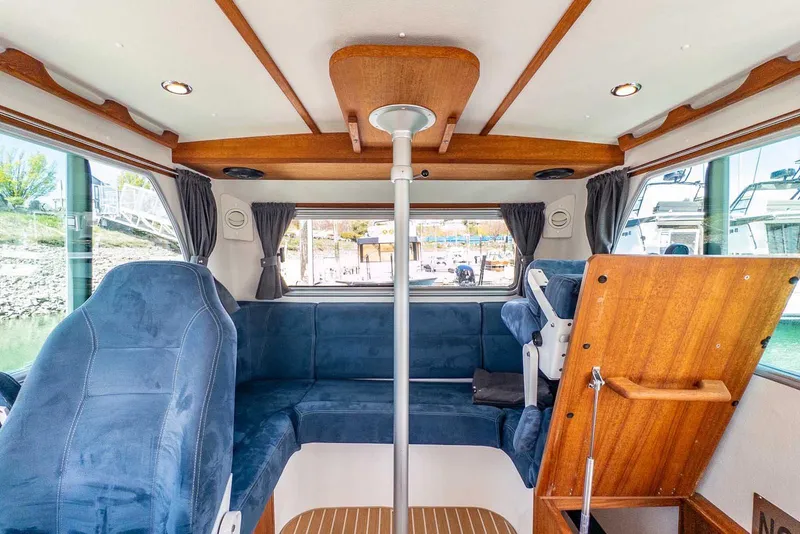 Slide: The Image of Interior of 2019 Nord Star 28 Patrol boat with blue seating and wooden accents. - 27