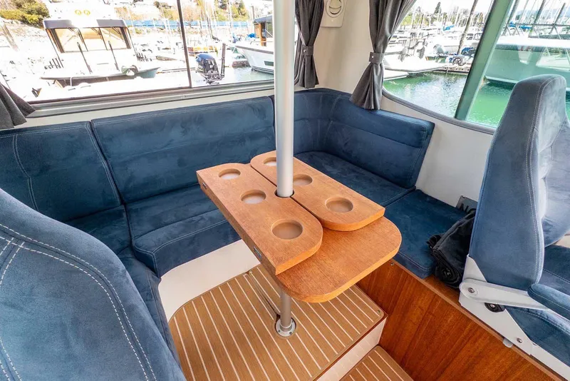 Slide: The Image of Interior of 2019 Nord Star 28 Patrol boat with blue seating and wooden table. - 28