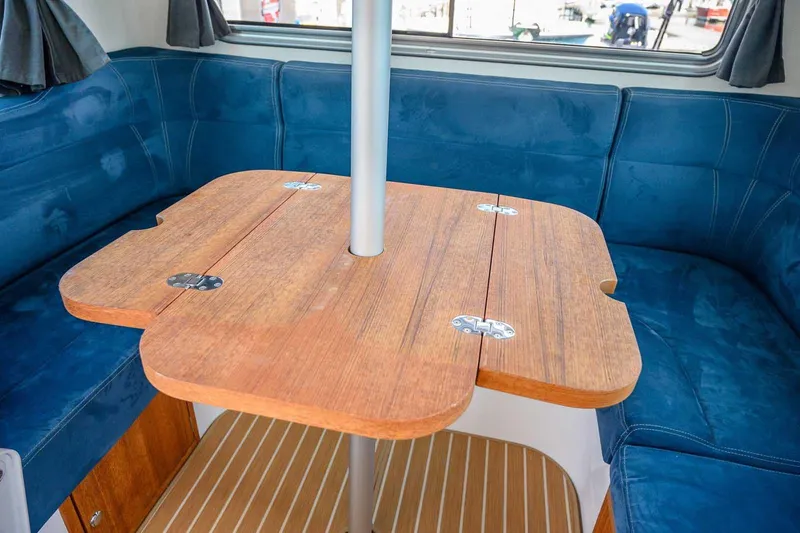 Slide: The Image of Interior of 2019 Nord Star 28 Patrol with wooden table and blue seating. - 29