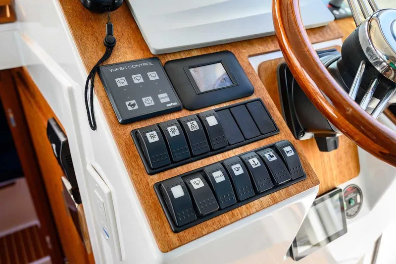 Slide: The Image of Control panel of 2019 Nord Star 28 Patrol boat with wooden accents and switches. - 32