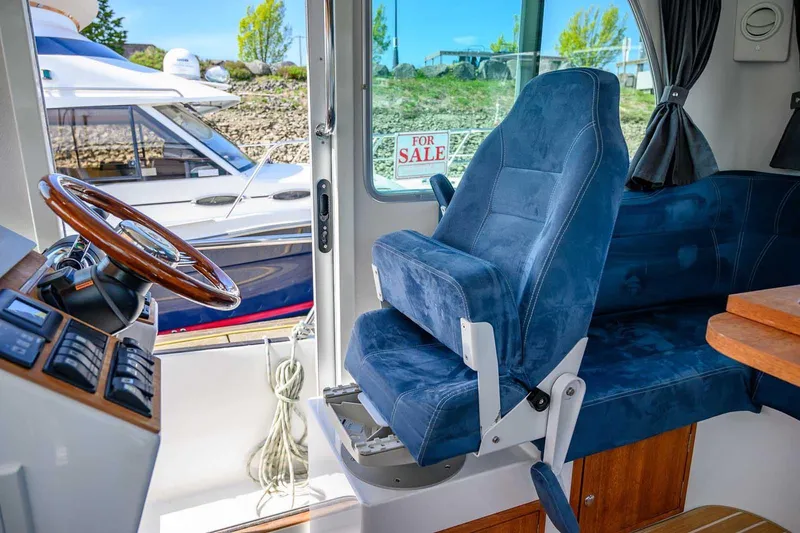 Slide: The Image of Interior of 2019 Nord Star 28 Patrol boat with blue seating and steering wheel. - 34