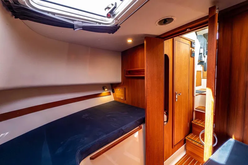 Slide: The Image of Cozy cabin interior of 2019 Nord Star 28 Patrol boat with wooden finishes and blue bedding. - 41