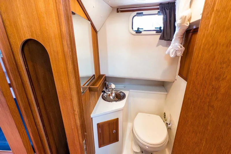 Slide: The Image of Compact bathroom in 2019 Nord Star 28 Patrol boat with wooden accents and porthole window. - 43