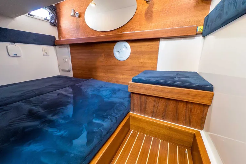 Slide: The Image of Cozy cabin interior of 2019 Nord Star 28 Patrol with wooden accents and blue cushions. - 45