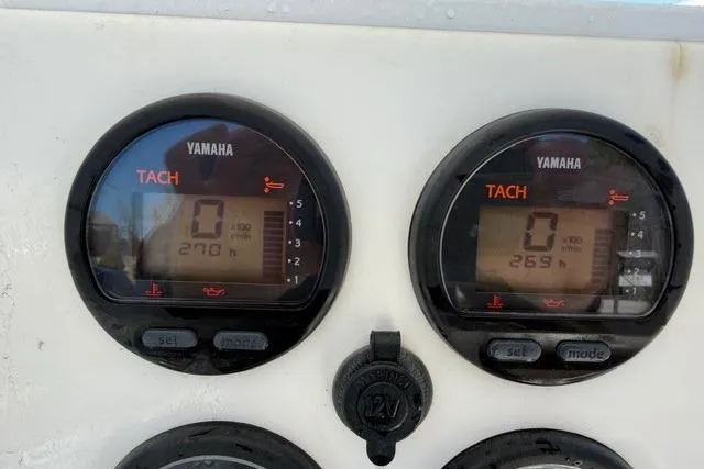 Slide: The Image of Yamaha tachometers on a 2004 Regulator 24 Forward Seating boat dashboard. - 12