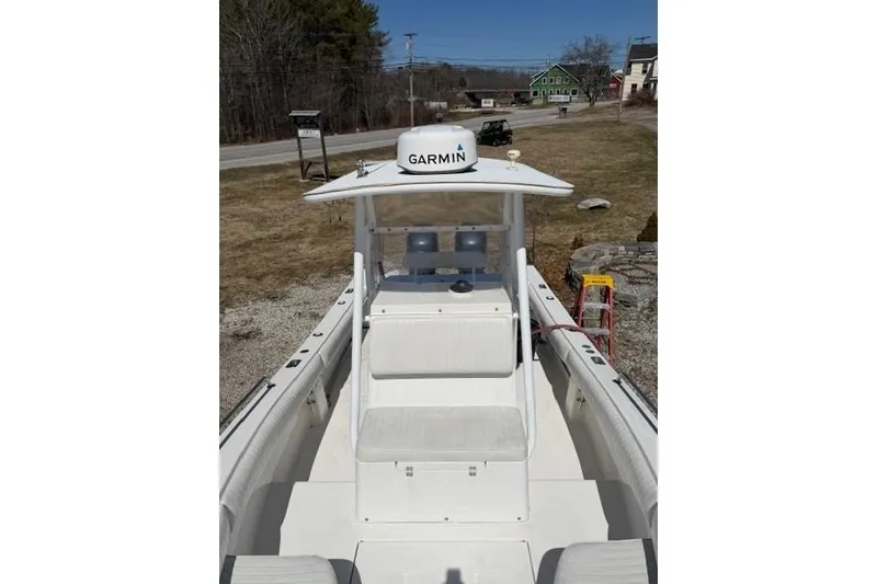 Slide: The Image of 2004 Regulator 24 Forward Seating boat with Garmin equipment, parked outdoors. - 6
