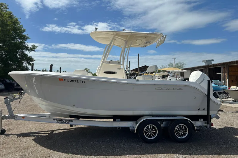 Slide: The Image of 2022 Cobia 220 Center Console boat on trailer under blue sky. - 1