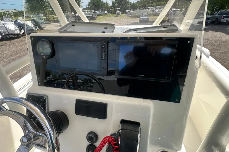 Slide: The Image of 2022 Cobia 220 Center Console dashboard with Garmin displays and steering wheel. - 10