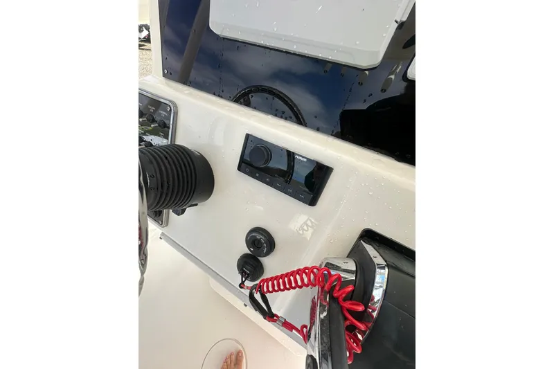 Slide: The Image of 2022 Cobia 220 Center Console dashboard with controls and steering wheel. - 11