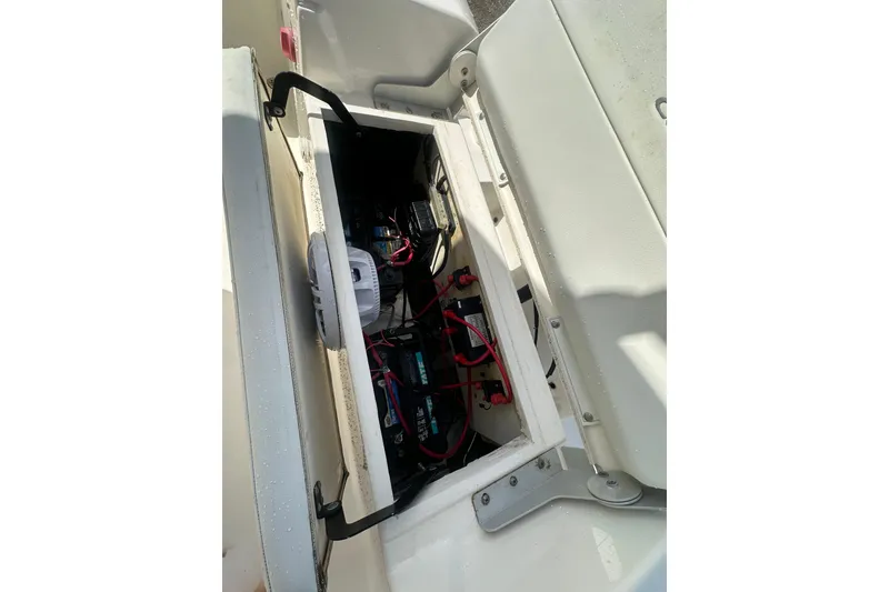 Slide: The Image of 2022 Cobia 220 Center Console boat battery compartment with wiring and components. - 14