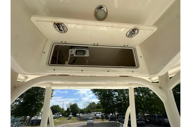 Slide: The Image of 2022 Cobia 220 Center Console boat with open storage compartment and electronic device. - 18