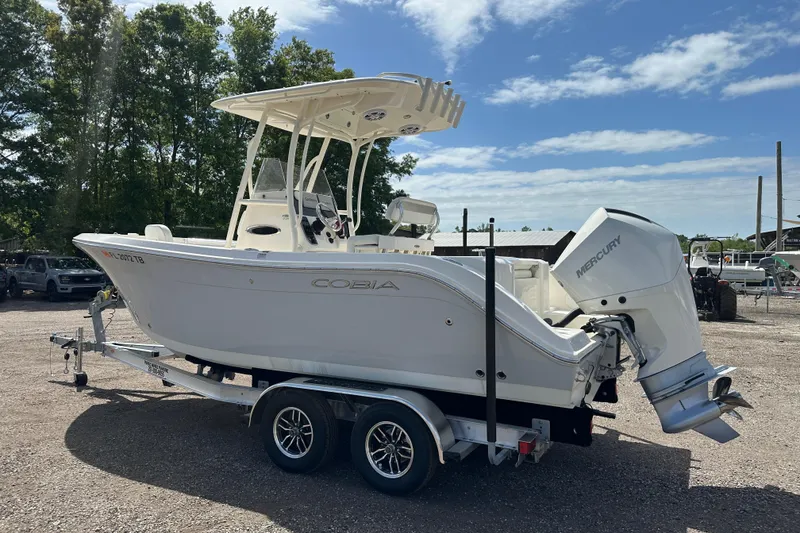 Slide: The Image of 2022 Cobia 220 Center Console boat on trailer, featuring Mercury outboard motor. - 2