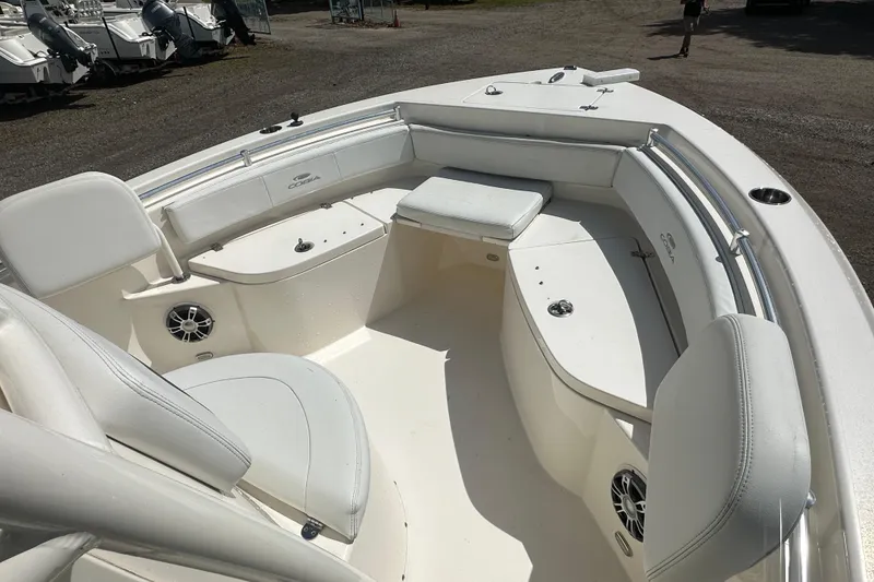 Slide: The Image of 2022 Cobia 220 Center Console boat interior with white seating and storage compartments. - 24