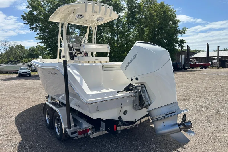 Slide: The Image of 2022 Cobia 220 Center Console boat with Mercury engine on trailer, parked outdoors. - 3