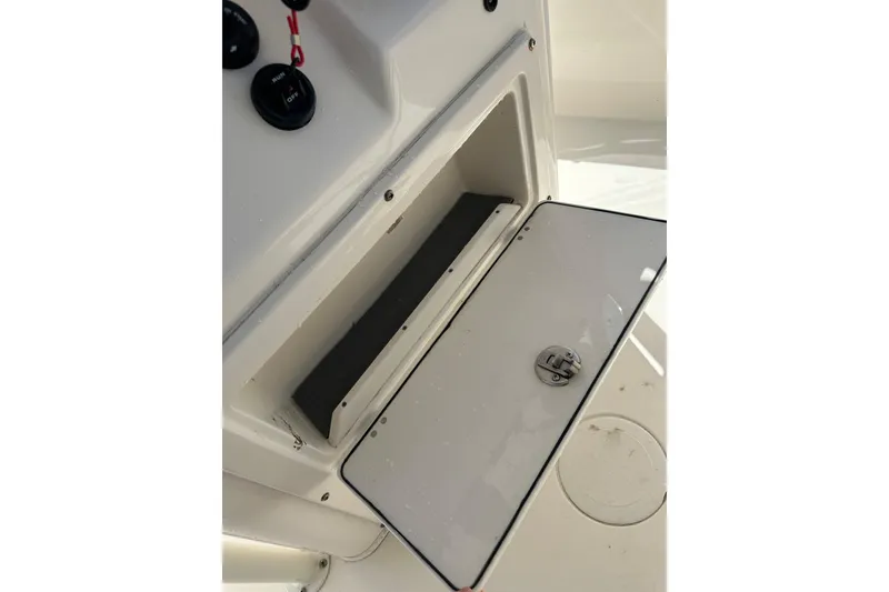 Slide: The Image of Open storage compartment on 2022 Cobia 220 Center Console boat. - 33