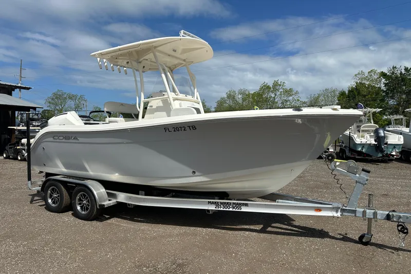 Slide: The Image of 2022 Cobia 220 Center Console boat on trailer under blue sky. - 8