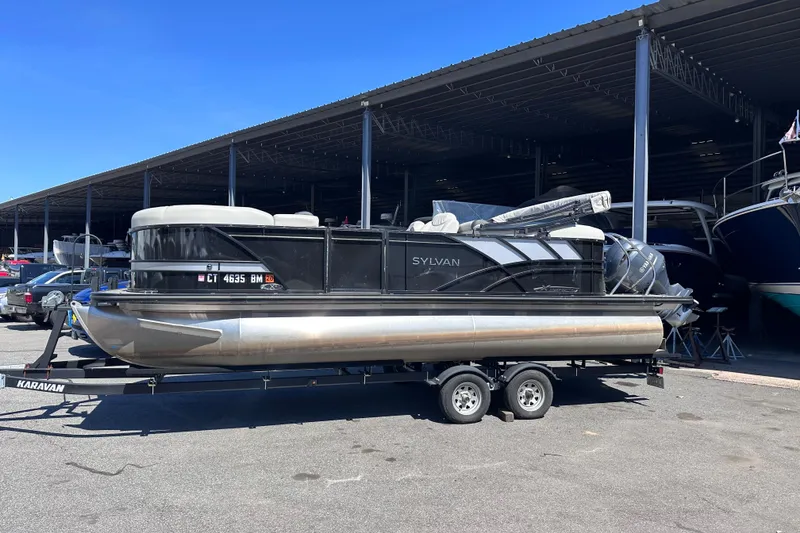 The Image of 2021 Sylvan Mirage X X3 pontoon boat on trailer in marina parking area. - 0