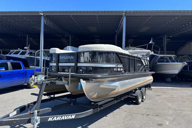 Slide: The Image of 2021 Sylvan Mirage X X3 pontoon boat on trailer in storage facility. - 1