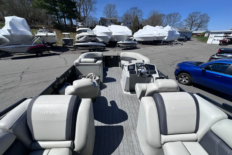 Slide: The Image of 2021 Sylvan Mirage X X3 pontoon boat with luxurious seating in a marina setting. - 10