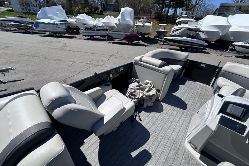 Slide: The Image of 2021 Sylvan Mirage X X3 pontoon boat interior with seating, parked among other boats. - 11