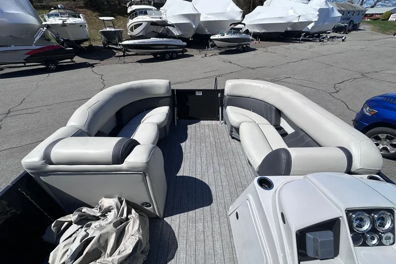 Slide: The Image of 2021 Sylvan Mirage X X3 pontoon boat interior with plush seating, parked among other boats. - 14
