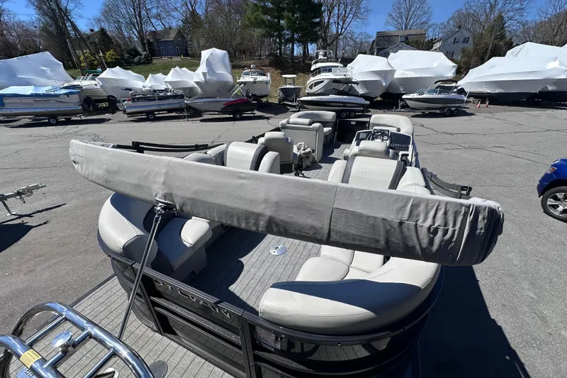 Slide: The Image of 2021 Sylvan Mirage X X3 pontoon boat in a marina with covered boats. - 7