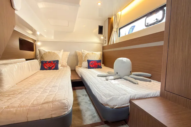 Slide: The Image of Luxurious cabin interior of 2026 Beneteau Antares 12 Coupe with twin beds and plush decor. - 11