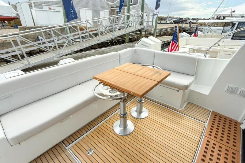 Slide: The Image of 2026 Beneteau Antares 12 Coupe yacht with elegant deck seating and wooden table. - 15