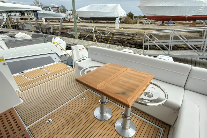 Slide: The Image of Deck view of 2026 Beneteau Antares 12 Coupe with seating and table. - 17