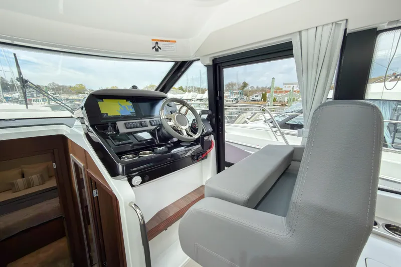 Slide: The Image of 2026 Beneteau Antares 12 Coupe helm with modern navigation system and comfortable seating. - 5
