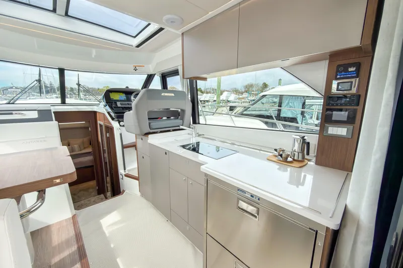 Slide: The Image of Interior of 2026 Beneteau Antares 12 Coupe yacht, featuring modern kitchen and helm. - 7