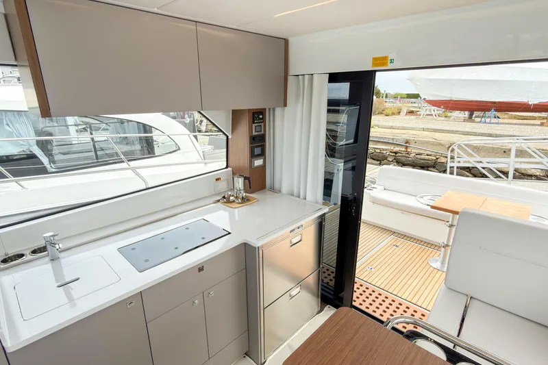 Slide: The Image of Modern kitchen interior of 2026 Beneteau Antares 12 Coupe yacht with outdoor seating. - 9