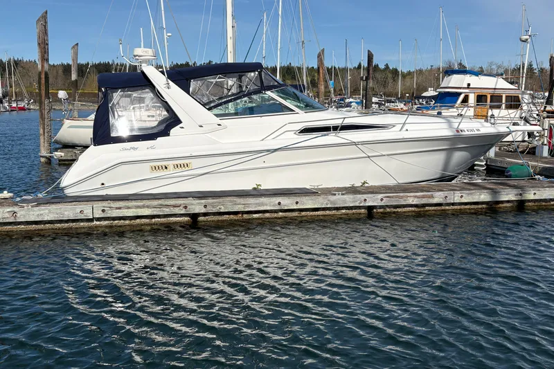 The Image of 1993 Sea Ray Sundancer 330 yacht docked at a marina, surrounded by calm waters. - 1