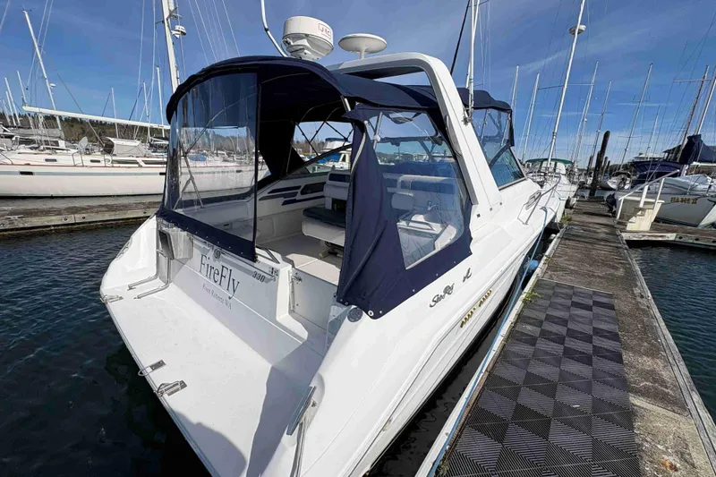 Slide: The Image of 1993 Sea Ray Sundancer 330 docked at marina, featuring blue canopy and sleek design. - 16