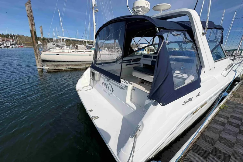 Slide: The Image of 1993 Sea Ray Sundancer 330 docked at marina, featuring blue canopy and spacious deck. - 17