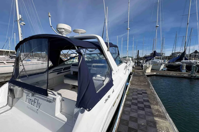 Slide: The Image of 1993 Sea Ray Sundancer 330 docked at marina, featuring blue canopy and sleek design. - 18