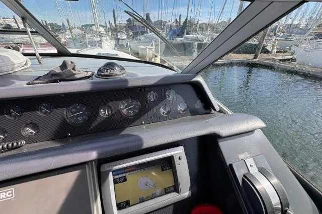 Slide: The Image of Cockpit view of a 1993 Sea Ray Sundancer 330, featuring navigation instruments and marina backdrop. - 59