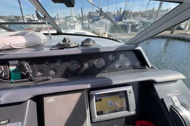 Slide: The Image of Cockpit view of a 1993 Sea Ray Sundancer 330, featuring navigation instruments and marina backdrop. - 60
