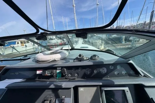 Slide: The Image of Cockpit view of a 1993 Sea Ray Sundancer 330 yacht docked at a marina. - 63