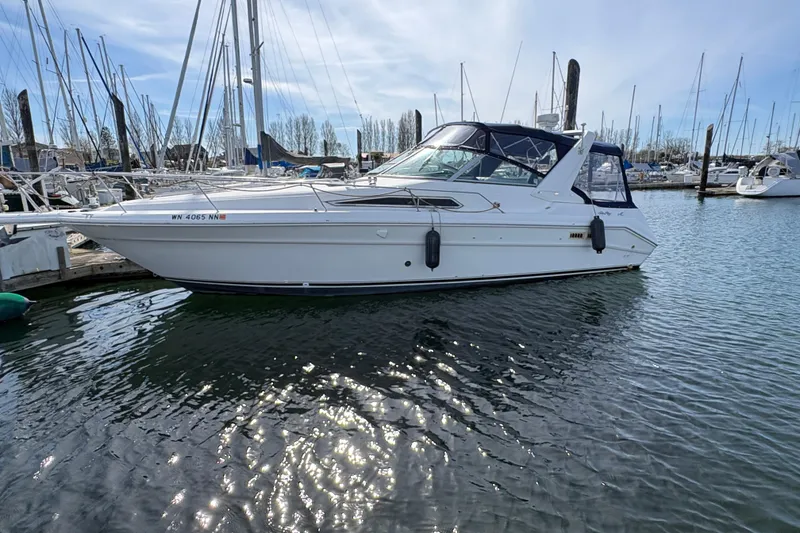 Slide: The Image of 1993 Sea Ray Sundancer 330 yacht docked in a marina under a clear sky. - 7