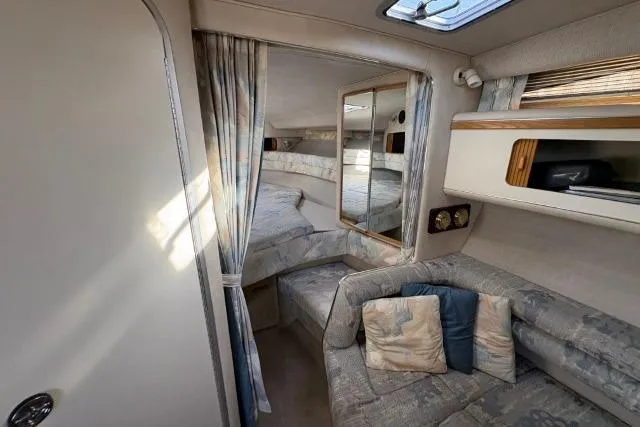 Slide: The Image of Interior of 1993 Sea Ray Sundancer 330, featuring cozy seating and a sleeping area. - 71