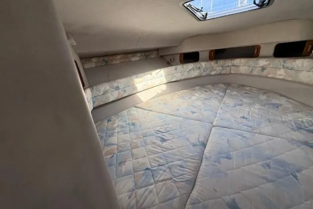 Slide: The Image of Interior cabin of 1993 Sea Ray Sundancer 330 with cushioned bedding and natural light. - 75